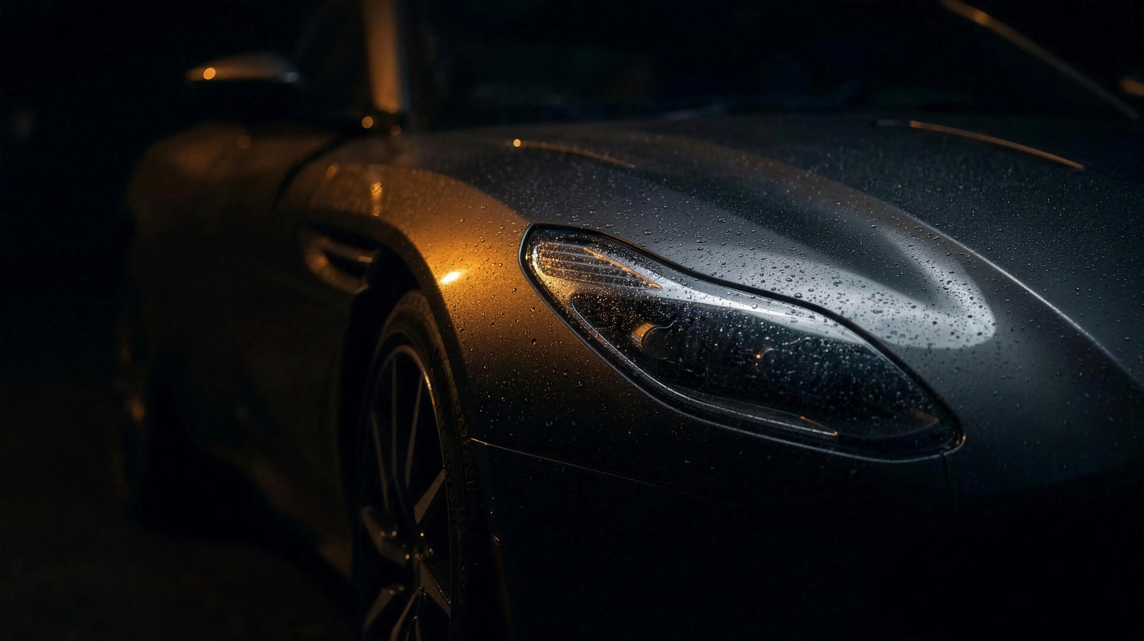 Macro shot of the fender and headlight, rain beading on the paint